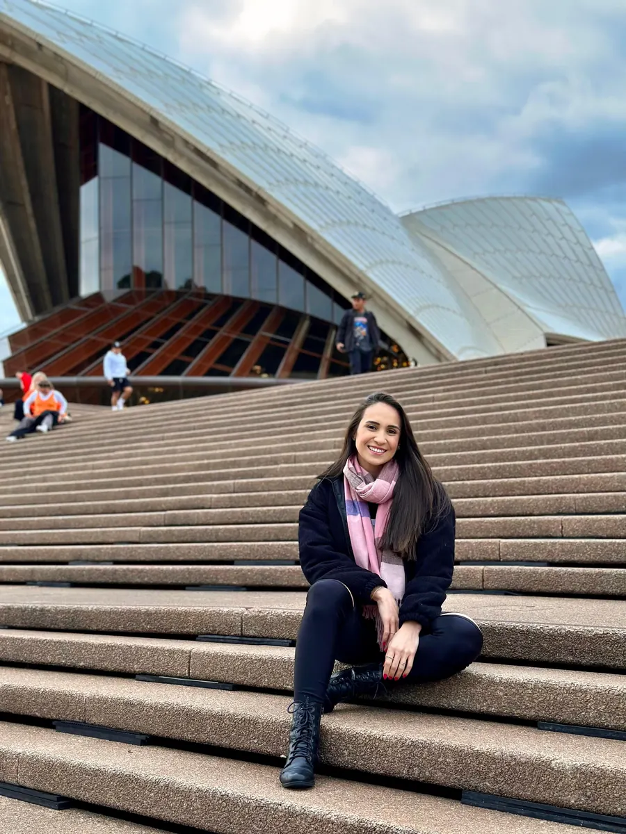 Bruna Rufino sentada en la escalinata de la Ópera de Sídney, en Australia